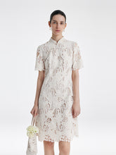 A lady wears a white mini lace dress.